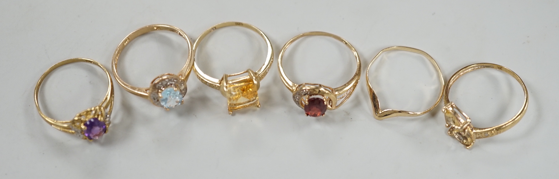 Five assorted modern 375 and gem set rings including amethyst and citrine, together with a 9ct wishbone shaped ring, gross weight 7.6 grams.